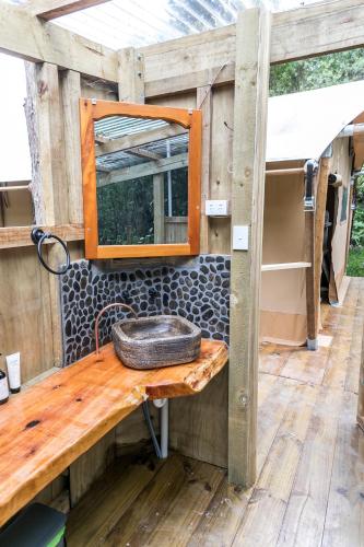 WaipapaRhino's Retreat的浴室水槽和木桌上的镜子
