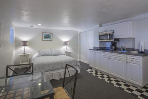 圣徒皮特海滩Sabal Palms Inn的一间卧室配有一张床铺和一张桌子,还设有一间厨房