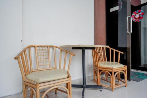 帕卢RedDoorz @ Hotel Bumi Palupy的桌子旁的两把椅子和一张桌子