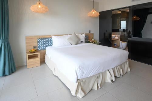 Loloata IslandLoloata Island Resort的一间带白色大床的卧室和一间浴室