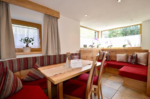 乌姆豪森兰德豪斯瓦尔德哈特酒店的一间带木桌和红色座椅的用餐室