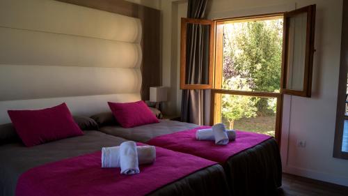 阿尔比尔Albir Garden Resort的一间卧室配有一张带粉色床单的大床和窗户。