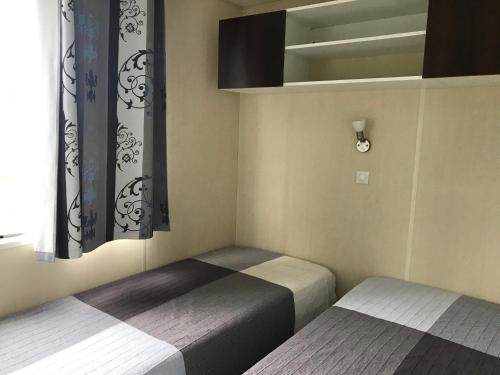 普拉加德阿罗Camping Castell D'aro的小型客房 - 带2张床和窗户
