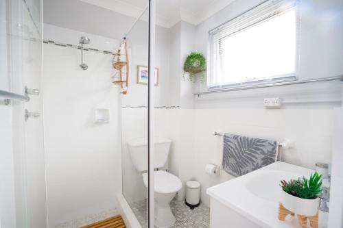 凯阿玛Sea Breeze Studio的白色的浴室设有卫生间和玻璃淋浴间。