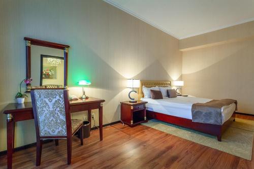 阿斯塔纳REIKARTZ PARK ASTANA ex-Royal Park Hotel & SPA的一间卧室配有一张床、一张桌子和一面镜子
