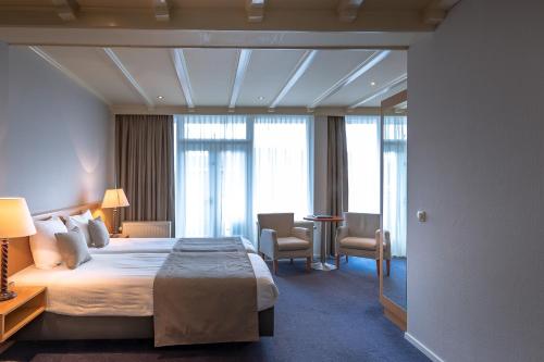 拉尔特Hotel Restaurant De Zwaan的酒店客房设有一张大床和窗户。