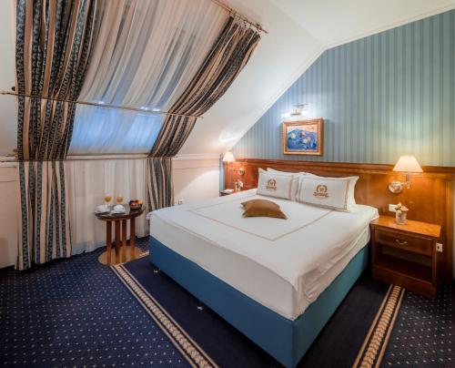奥西耶克瓦尔丁格酒店的一间设有大床和窗户的酒店客房