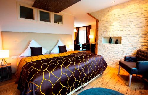 伊尔森堡REGIOHOTEL Naturresort Ilsenburg的一间卧室设有一张大床和砖墙