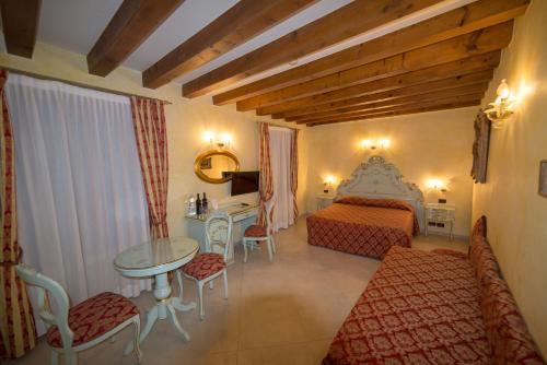 威尼斯Locanda Ca' Zose的酒店客房带一张床、一张桌子和椅子