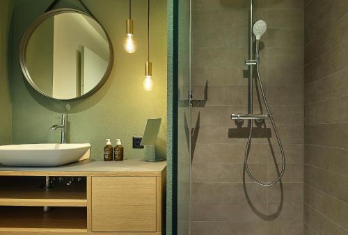 苏斯坦Links Leuk Golfresort的带淋浴、水槽和镜子的浴室