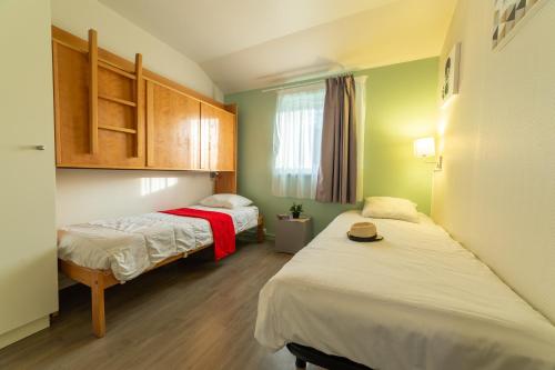 弗尔黎祖VVF Normandie Forges-les-Eaux的小型客房 - 带两张床和绿色墙壁
