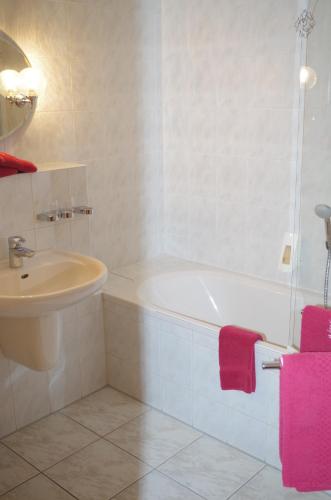 莱比锡祖默艾博斯朋霍夫酒店的浴室配有白色浴缸和水槽