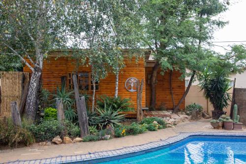 伯诺尼Blyde Africa- Cottage的房屋前有游泳池的房子