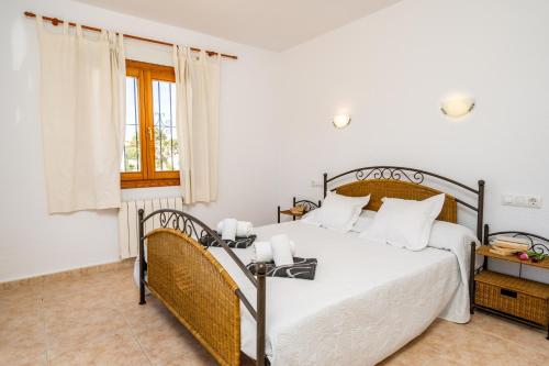 哈维亚卡尔佩戴姆度假屋的一间卧室配有一张带白色床单的床和一扇窗户。