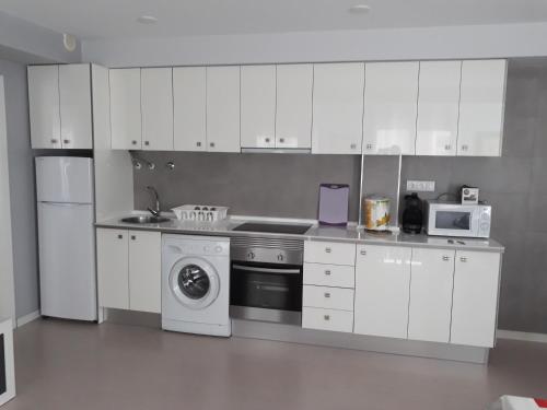 圣波拉Apartamentos Centro的厨房配有白色橱柜和洗衣机。