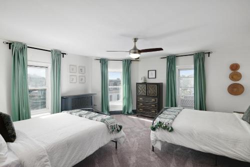 费城Modern Parisian Apartment in the Heart of Manayunk的配有绿窗帘和窗户的客房内的两张床