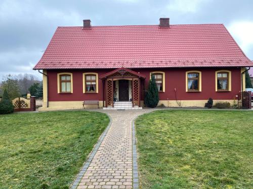 BiałlaAgro na Wapniarni的草场上红色屋顶的红色房子