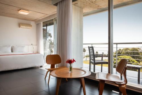 科洛尼亚-德尔萨克拉门托哥斯达科隆尼亚河畔精品酒店的酒店客房带一张床、一张桌子和椅子