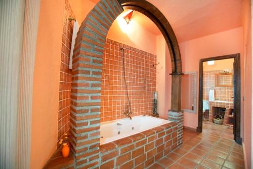 RebollarCasa Rural Las Gamellas的砖墙内带浴缸的浴室