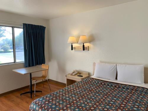 西尔马Vagabond Inn Sylmar的配有一张床、一张书桌和一扇窗户的酒店客房