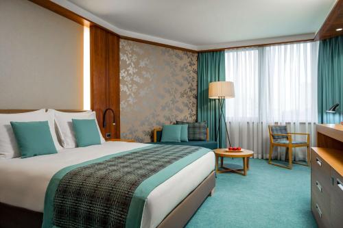 布拉柴维尔布拉柴维尔玛拜波宫丽笙酒店的酒店客房带一张大床和一把椅子
