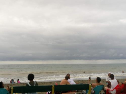 努基Hotel OBEGA PACIFIC的一群人坐在海滩上