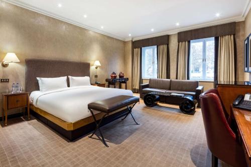 伦敦Radisson Blu Hampshire Hotel, London的酒店客房配有一张床、一张沙发和一张书桌。