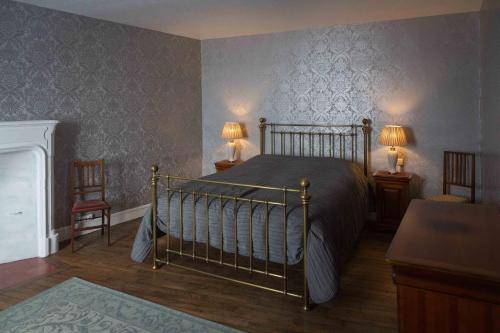 蒙莫里永La Bicyclette Bleue的一间卧室配有一张床、两张桌子和两盏灯。