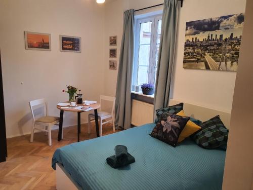 华沙RentOnline Kościelna Apartment Old Town的一间卧室配有一张床、一张桌子和一个窗户。