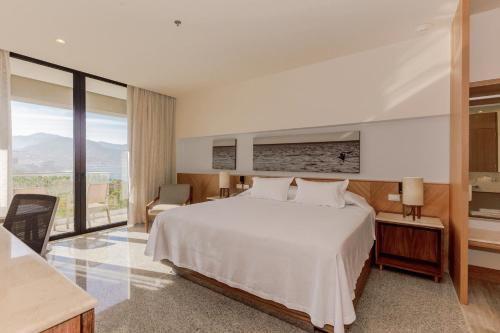 巴亚尔塔港Hotel Mio Vallarta Unique & Different- Adults Only的卧室设有白色的床和大窗户