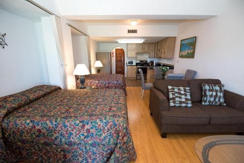 Pembroke风之歌公寓的一间卧室配有一张床和一张沙发,还设有一间厨房