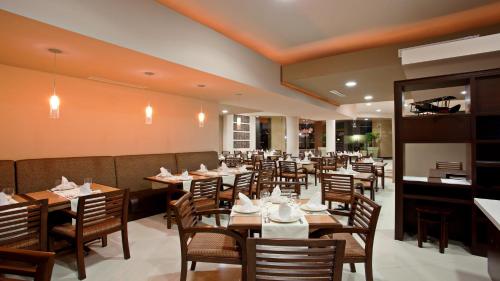 提华纳假日酒店里约提华纳店的用餐室配有木桌和椅子