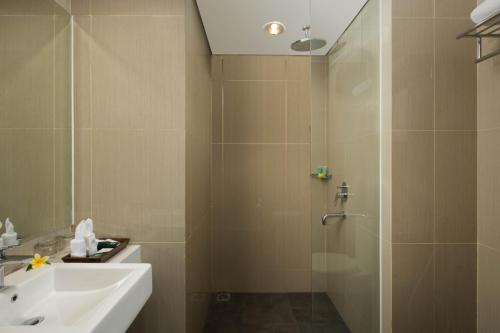 日惹KHAS Tugu Hotel Yogyakarta的带淋浴、盥洗盆和盥洗盆的浴室