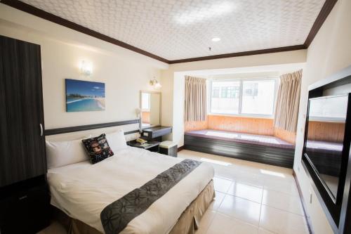 恒春古城垦丁马尔地夫温泉大饭店的酒店客房设有一张床和一个大窗户