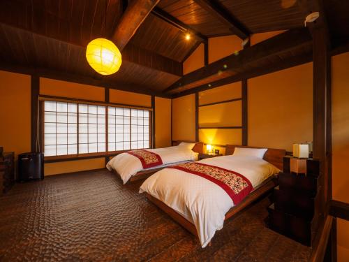 京都100 years old traditional Kyoto Machiya townhouse - K's Villa的一间卧室设有两张床和大窗户