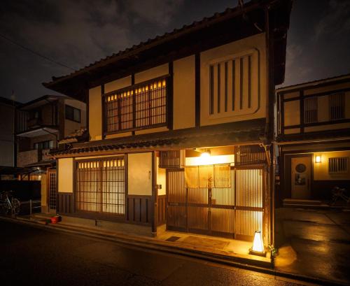 京都100 years old traditional Kyoto Machiya townhouse - K's Villa的一座建筑物,晚上有灯