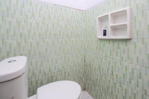 KetapangOYO 2042 Zam Zam Family Syariah的浴室设有白色卫生间和绿色瓷砖墙壁。