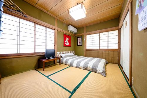 富士吉田市旭阳度假屋的一间设有床铺和笔记本电脑的房间