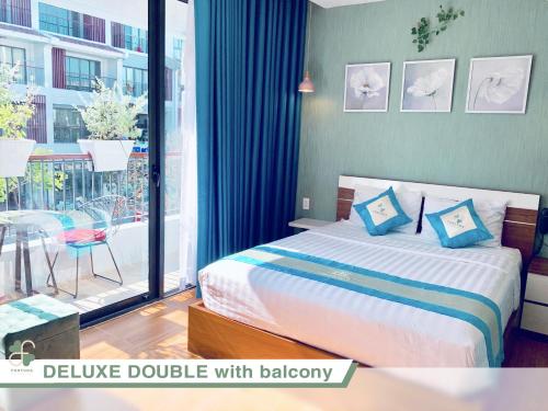 富国FLORA Hotel Phu Quoc的一间卧室配有一张带蓝色枕头的床和一个阳台