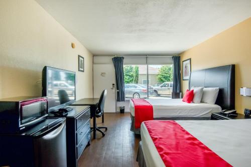 奥兰多Hotel Belair Orlando Near Florida Mall的酒店客房设有两张床和一台平面电视。