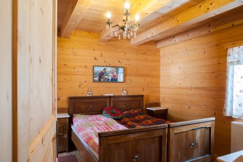 PodjeljePodjelje的木制客房内的一间卧室,配有一张床