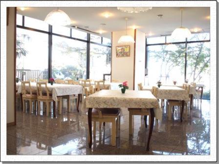 泉佐野新裕酒店的用餐室设有桌椅和窗户。