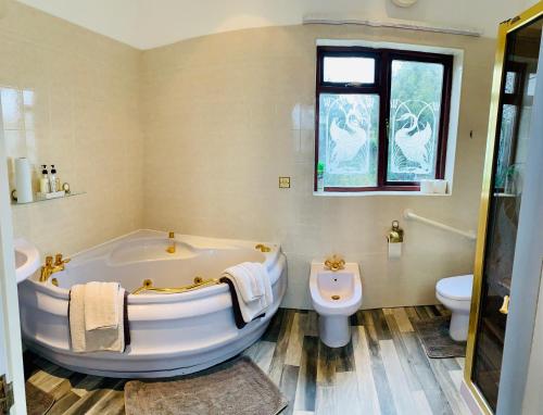 纽尼顿White Wings的白色的浴室设有浴缸和卫生间。
