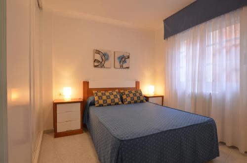 拉科萨Apartamentos Xulia的一间卧室配有蓝色的床和2个床头柜