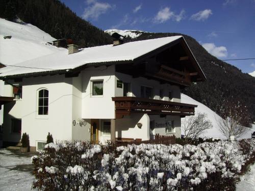 图克斯Ferienwohnung Alpenheim的白色的房子,上面有雪