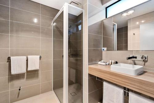 霍巴特Foreshore Hotel的带淋浴、盥洗盆和镜子的浴室