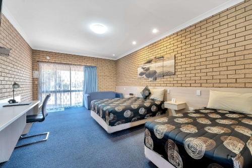 华威Warwick Settlers Inn的酒店客房配有两张床和一张书桌