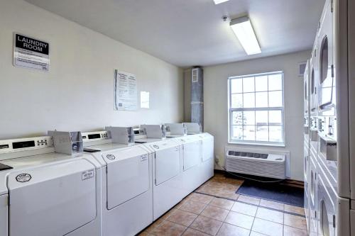 威斯敏斯特Suburban Studios Westminster Denver North的洗衣房配有白色洗衣机和窗户