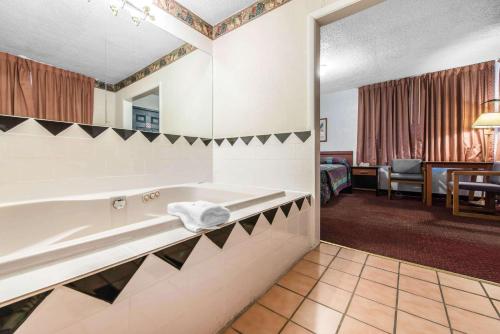 科罗拉多斯普林斯科罗拉多斯普林斯罗德威套房酒店的一间带浴缸的浴室和一间客房
