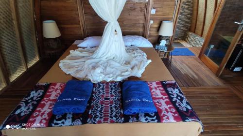 BaingWajonata Sumba的一张带两个枕头的床,上面有一件连衣裙